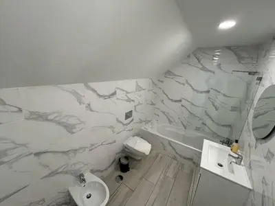 a bathroom with white marble walls and a sink at Casa Susana in Faro