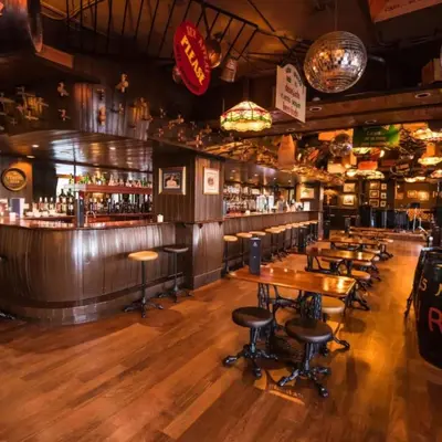 a bar with wooden floors and tables and bar stools at Hotel Vila Galé Cerro Alagoa in Albufeira