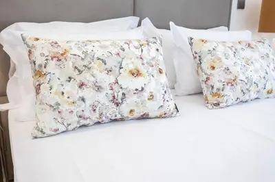 two pillows on a bed with white sheets at Terracos de Quarteira Orange by Real Properties in Quarteira
