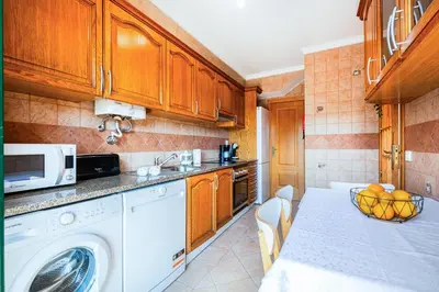a kitchen with a washing machine and a microwave at Villa Lamella in Albufeira