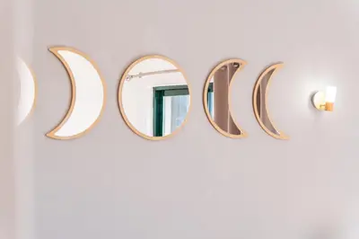 a mirror in the shape of the word ucci hangs on a wall at Villa Lamella in Albufeira