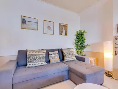 a living room with a blue couch in a room at Apartamento Alvaflor com Piscina – Vilamoura in Quarteira