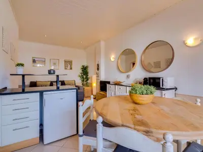 a kitchen with a wooden table and a dining room at Apartamento Alvaflor com Piscina – Vilamoura in Quarteira