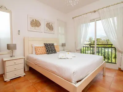 a bedroom with a large white bed with wooden cabinets at Quinta do Paiva Apartment by Stay ici Algarve Holiday Rental in Albufeira