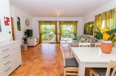 a living room with a table and a couch at Quinta do Paiva Apartment by Stay ici Algarve Holiday Rental in Albufeira