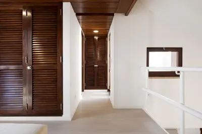 a hallway with wooden doors and white walls at Marina Club II - Marina view by HD in Vilamoura