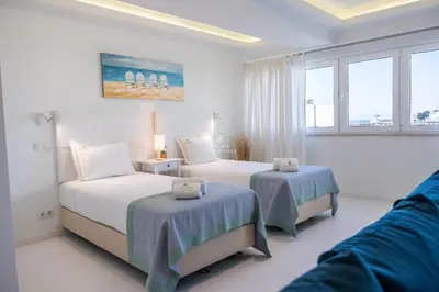 two beds in a white room with windows at Downtown Studio - By D`alma Portuguesa in Albufeira