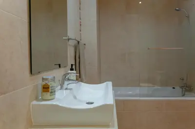 a bathroom with a white sink and a bath tub at Moradia Flaj in Olhos de Água