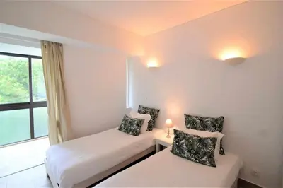 a small room with two beds and a window at Casa das Areias in Albufeira