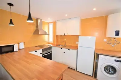 a kitchen with a white refrigerator and a dishwasher at Casa das Areias in Albufeira