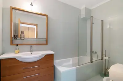 a bathroom with a sink and a shower and a mirror at Algarve Apartment, Faro - Excellent Location in Faro