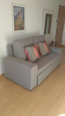 a gray couch with two pillows in a living room at Algarve Apartment, Faro - Excellent Location in Faro
