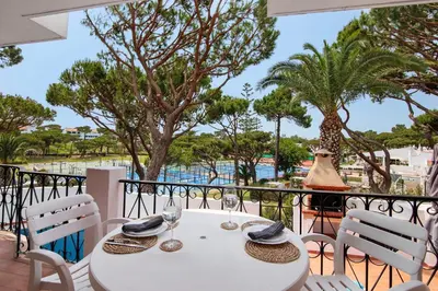 a white table and chairs with a view of the water at Apartamento Tennis View in Almancil