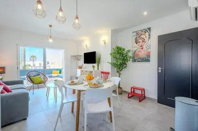 a living room with a white table and chairs at Albufeira Old Town Sea View Apartment in Albufeira
