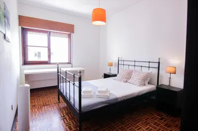 a bedroom with a black bed and a window at 4 Bedroom in Faro Downtown in Faro