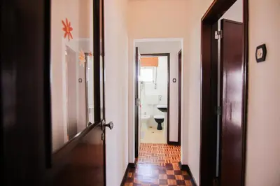 a hallway leading to a bathroom with a toilet at 4 Bedroom in Faro Downtown in Faro
