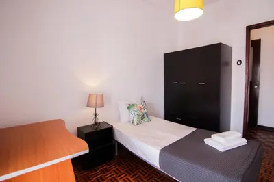 a small bedroom with a bed and a dresser at 4 Bedroom in Faro Downtown in Faro