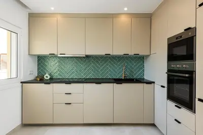 a kitchen with white cabinets and black appliances at The Marina Collection in Quarteira