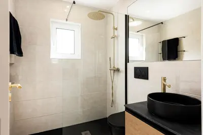 a bathroom with a black sink and a shower at The Marina Collection in Quarteira