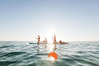 a group of people on a surfboard in the water at #312 Ocean Outlook by Home Holidays in Páteo