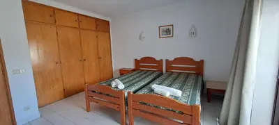 a bedroom with a wooden bed with towels on it at Caranguejo Apartment in Albufeira