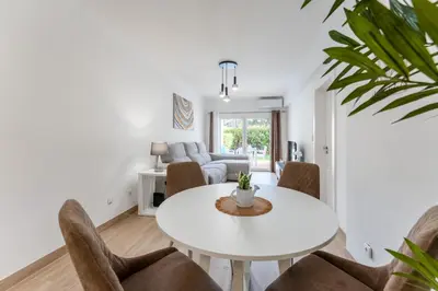a living room with a white table and chairs at Apartamento Pine by Algarve Holidays in Roja- Pé