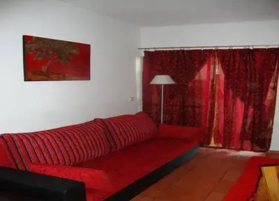 a red couch in a living room with a window at Apartamento Ariadna in Albufeira