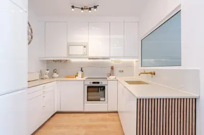 a white kitchen with white cabinets and a sink at Sandora Dune by Seareen in Albufeira