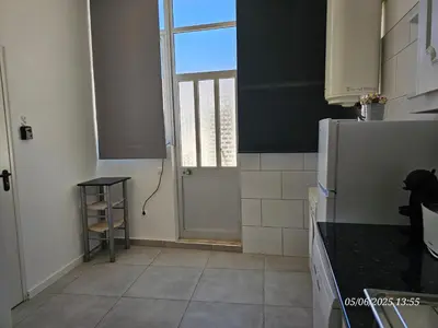 a kitchen with a refrigerator and a window and a door at Blife Montya private rooms in Faro