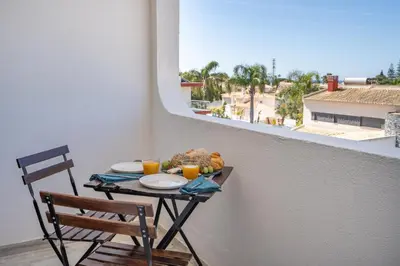 a table with food and orange juice on a balcony at Seaside Charm Flat w/ Balcony by HostWise in Albufeira