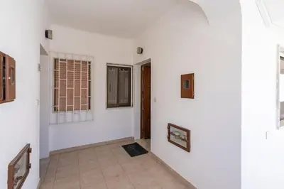 a room with white walls and a hallway with windows at Seaside Charm Flat w/ Balcony by HostWise in Albufeira