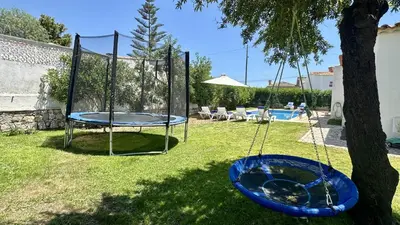 a trampoline in a yard next to a tree at Strip II by Check-in Portugal in Albufeira