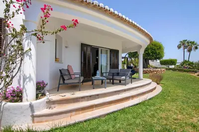 a home with a patio with chairs and flowers at Villa Rose in Albufeira