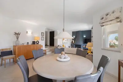 a dining room and living room with a table and chairs at Villa Rose in Albufeira