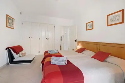 a bedroom with two beds and a chair at Villa Rose in Albufeira