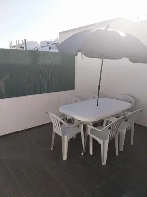 a white table and chairs with an umbrella at Albufeira Oura Apartment II in Albufeira