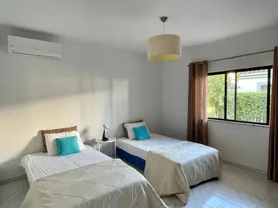 a bedroom with two beds and a window at Vivenda Duas Sentinelas 42 in Quarteira