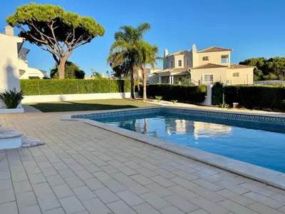 a swimming pool in front of a house at Vivenda Duas Sentinelas 42 in Quarteira
