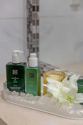 a tray with two bottles of soap and a flower at Casa do sol in Olhos de Água