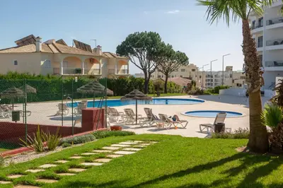 a resort with a swimming pool and palm trees at Casa do sol in Olhos de Água
