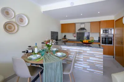 a kitchen with a table and chairs in a room at Casa do sol in Olhos de Água