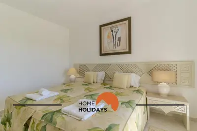 a bedroom with a bed with a home holidays sign on it at #315 Apartamento Turistico by Home Holidays in Atalaia