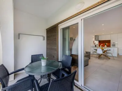 a dining room with a table and chairs and a living room at Apartment Sol Salgado by Interhome in Albufeira