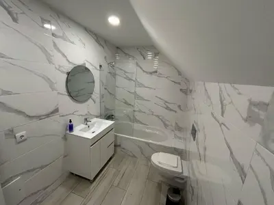 a white bathroom with a toilet and a sink at Casa Madalena in Faro