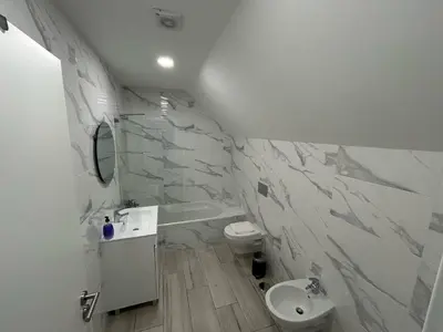 a white bathroom with a toilet and a sink at Casa Madalena in Faro