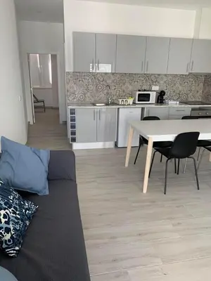 a kitchen and a living room with a table and a couch at Casa Foka in Faro