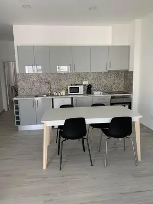 a kitchen with a white table and chairs in it at Casa Foka in Faro