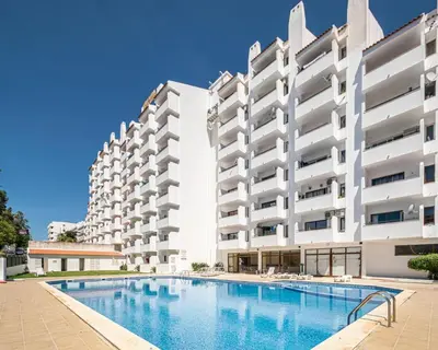 a swimming pool in front of a building at SMILE Apartment Albufeira in Albufeira