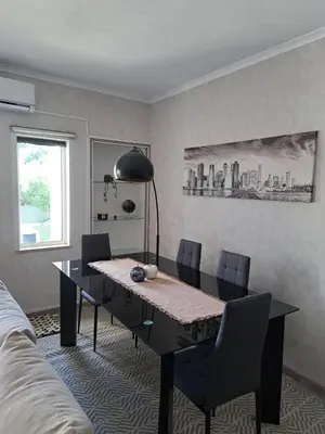 a dining table and chairs in a living room at SMILE Apartment Albufeira in Albufeira