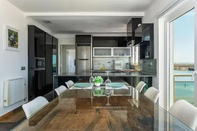 a kitchen and dining room with a glass table and chairs at Blife Charlya private apartment at Faro beach in Faro